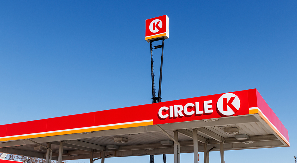 Circle K sign and roof of gas pump station pictured with a blue sky in the background.