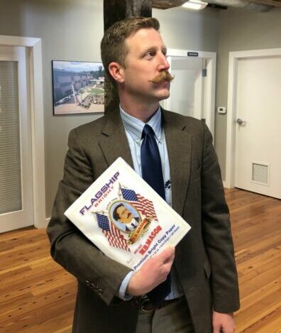 Kevin twinning with a Flagship Bright bundle of paper that has a man with a mustache in a suit looking right.