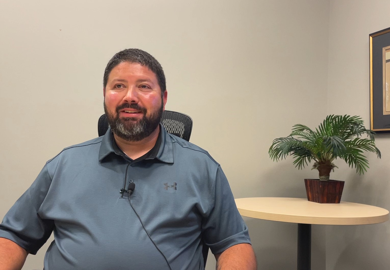 Justin Lilly, an SUE expert, wears a grey polo shirt for a video interview.