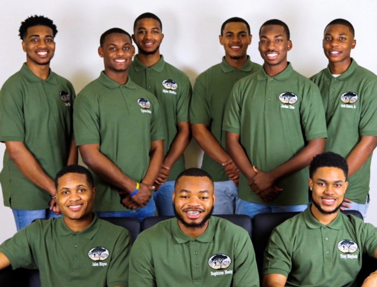 Jalen with his Village Mentoring group taking a group photo wearing the same sage green shirts.