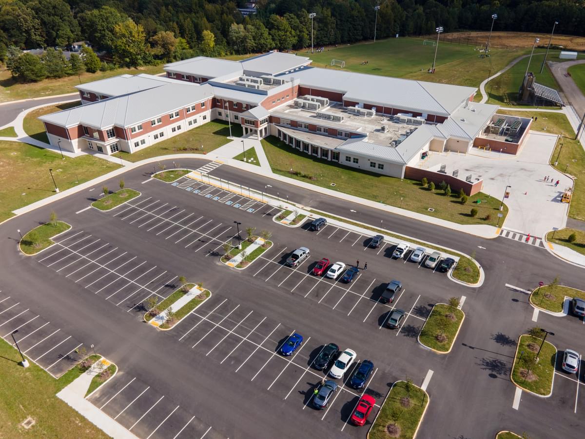 Front aerial view of the new Manchester Middle School, featuring the parking lot, school, and soccer field.