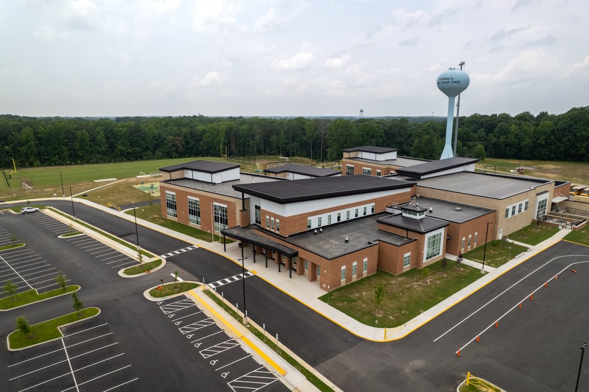 Front aerial view of the new Middle Road Elementary School, featuring the parking lot and water tower.