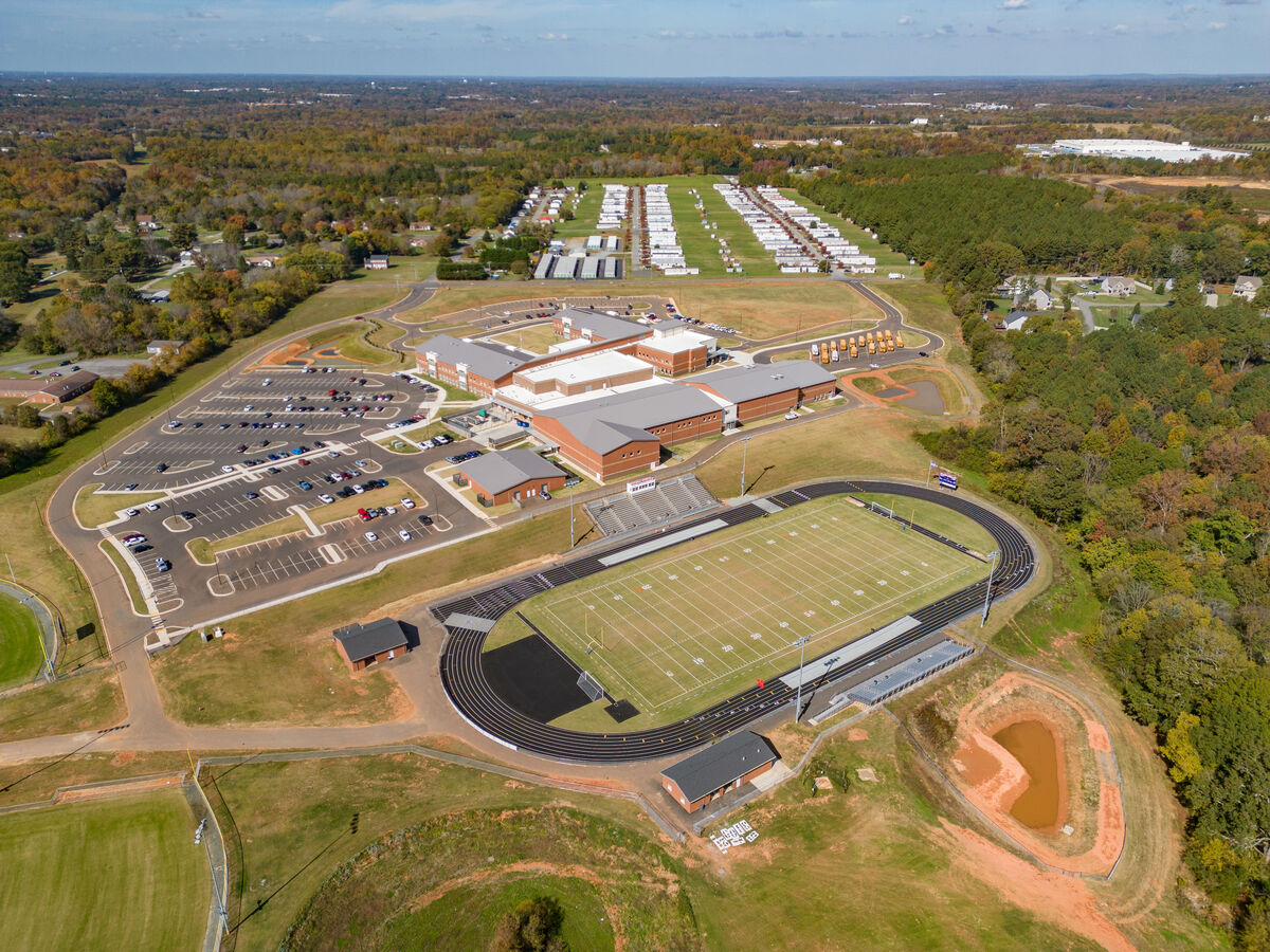 Aerial photo of Southeast Alamance High School, Haw River, North Carolina showing the football field with track, the school, and the parking lots.