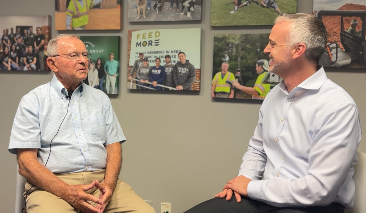 Jim Hayes sitting on the left and Tim Klabunde sitting on the right in front of a wall decorated with photo canvases.