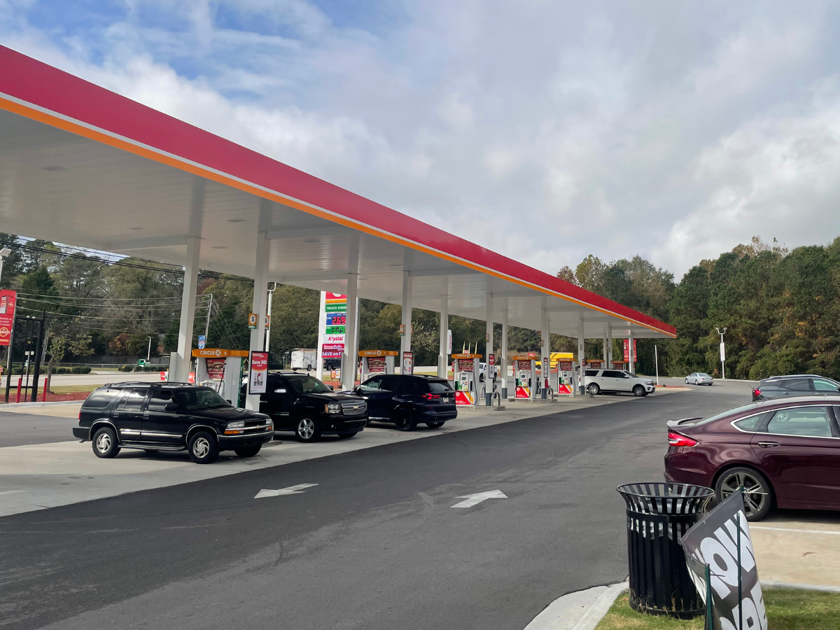 Pictured is a Circle K gas station parking lot, showcasing the white arrows that point in the direction to drive.